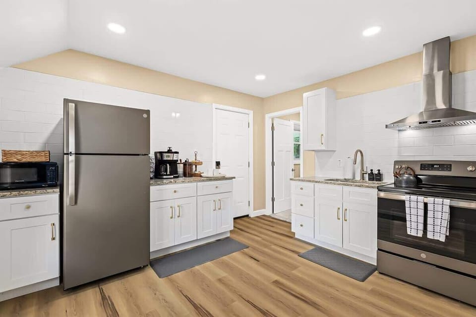 This kitchen is fully equipped with a stove, oven, sink, and refrigerator. There is also a microwave, toaster, and coffee maker.