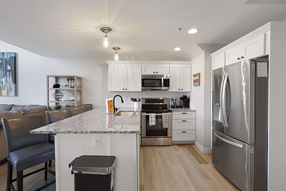 Your modern kitchen features granite countertops, stainless steel appliances, and a breakfast bar perfect for morning coffee or casual dining.