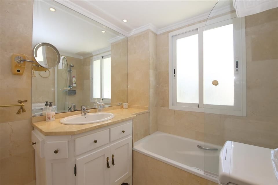 En-suite bathroom to the master bedroom with bath, shower, toilet and hand basin