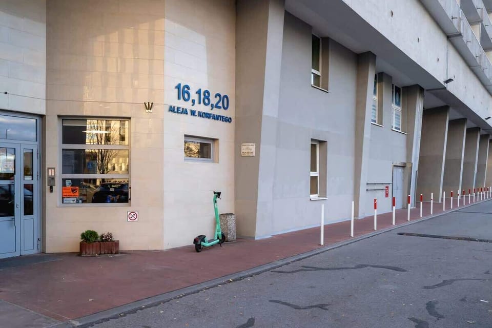 The exterior of the building, featuring a ground-level commercial space with signage.

