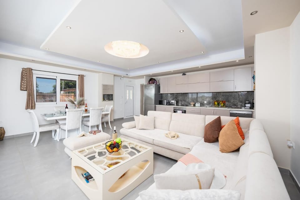 Open-plan living room with sofa, dining area, kitchen, A/C, WiFi internet, and satellite TV