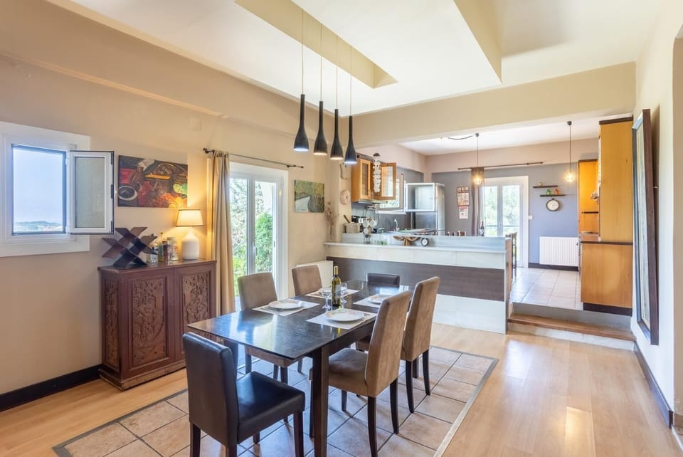 Open-plan living room with sofas, dining area, kitchen, ornamental fireplace, WiFi internet, and satellite TV