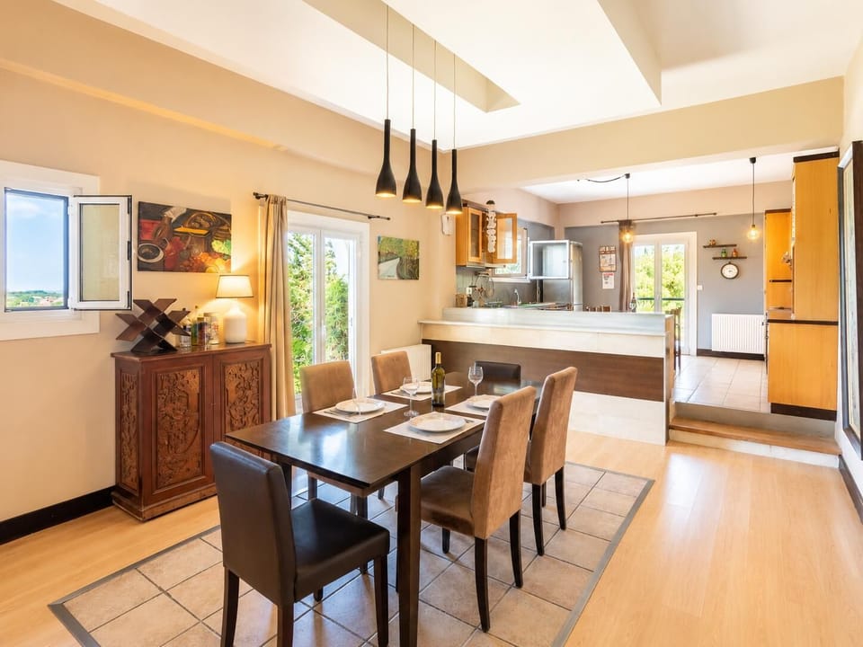 Open-plan living room with sofas, dining area, kitchen, ornamental fireplace, WiFi internet, and satellite TV