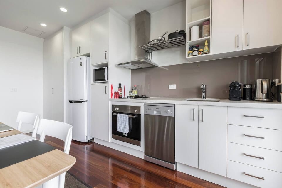 An open-plan, stylish kitchen features new stainless steel appliances, a top of the range oven, all kitchen tools and utensils, and a large LG refrigerator