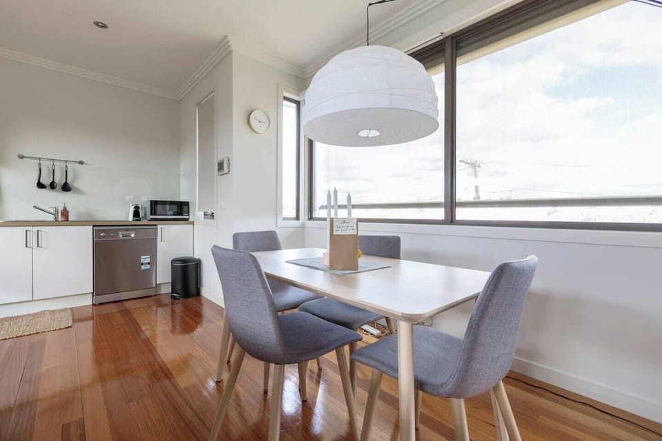 Open-plan living has the lounge room sitting alongside a wooden dining table for up to four guests  