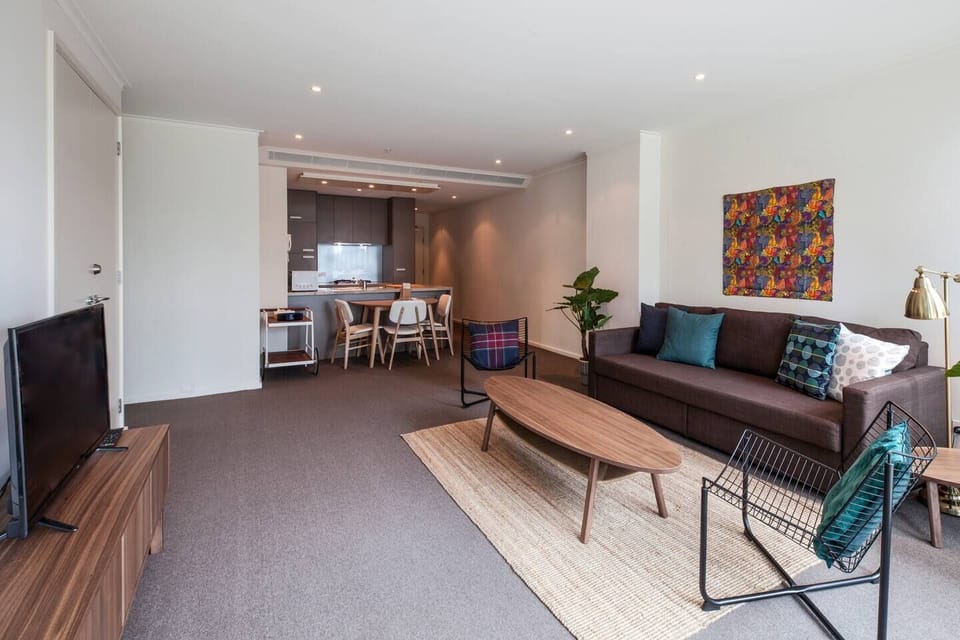 A light-filled living room comes furnished with a plush couch, additional chair and a 42" HDTV and is ideal for relaxing