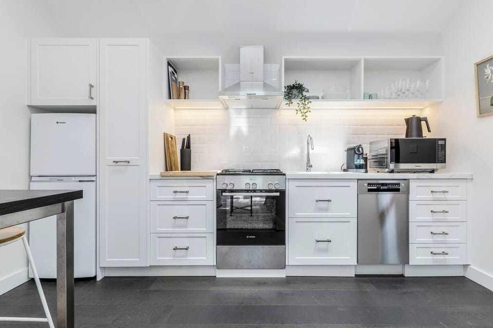 A gorgeous kitchen is equipped with sleek appliances and cooking utensils.
