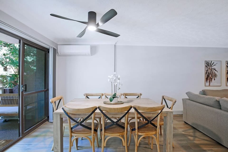 The open-plan dining area features a spacious eight-seater table, with sliding glass doors opening to the private balcony. 

