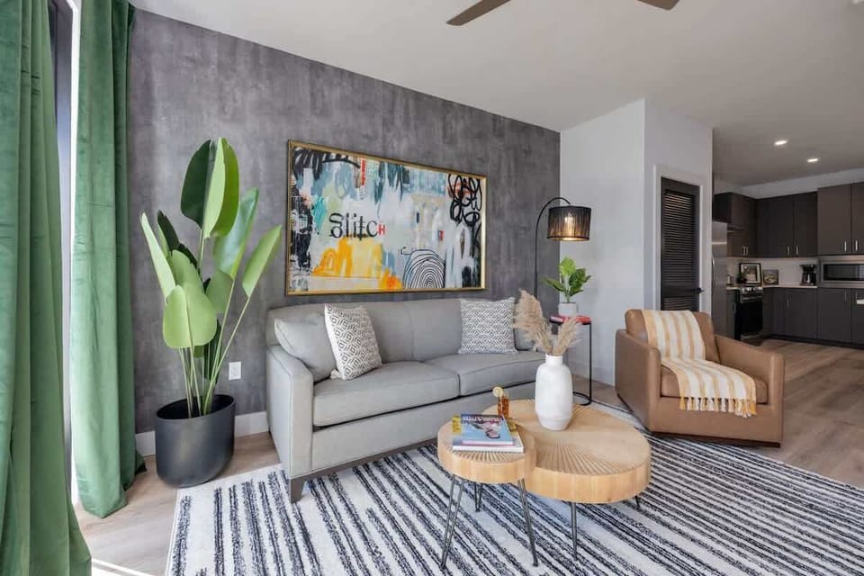 Bright open living space featuring a smart flat-screen TV, designer furnishings, and access to the patio.