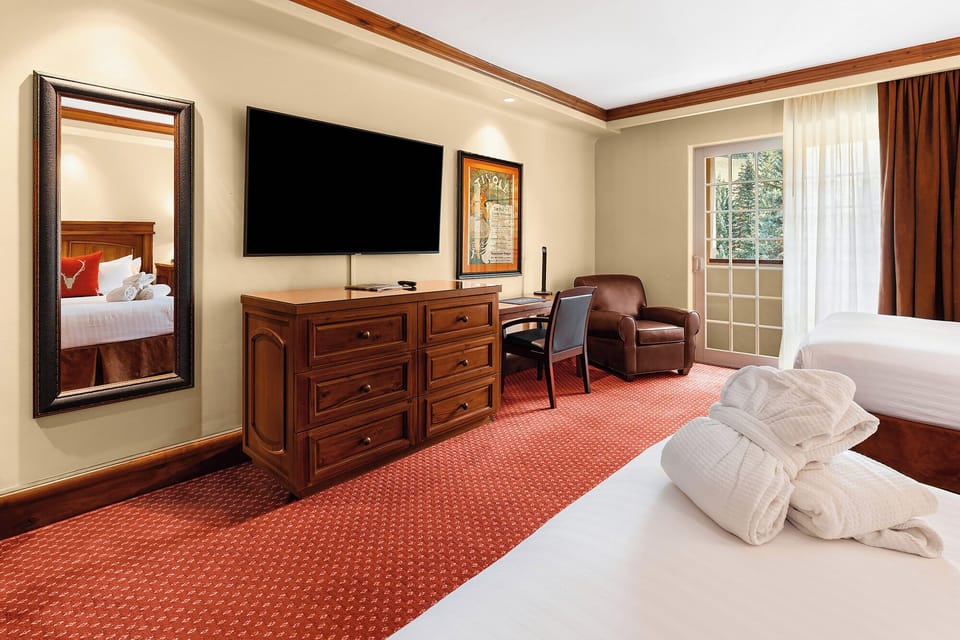 Unwind in a spacious bedroom with lounge chair and big TV.