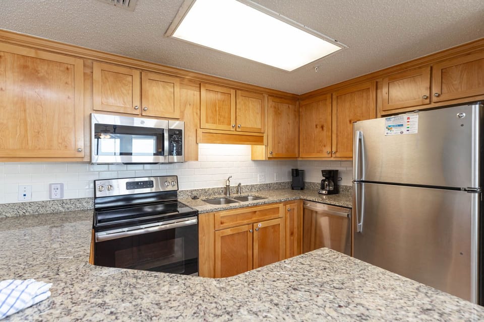 Cook and gather in this spacious kitchen featuring granite countertops, stainless appliances, and wooden cabinetry