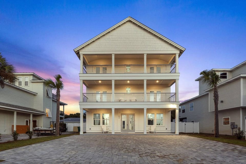 Grand exterior view w/ balconies and warm evening lighting.