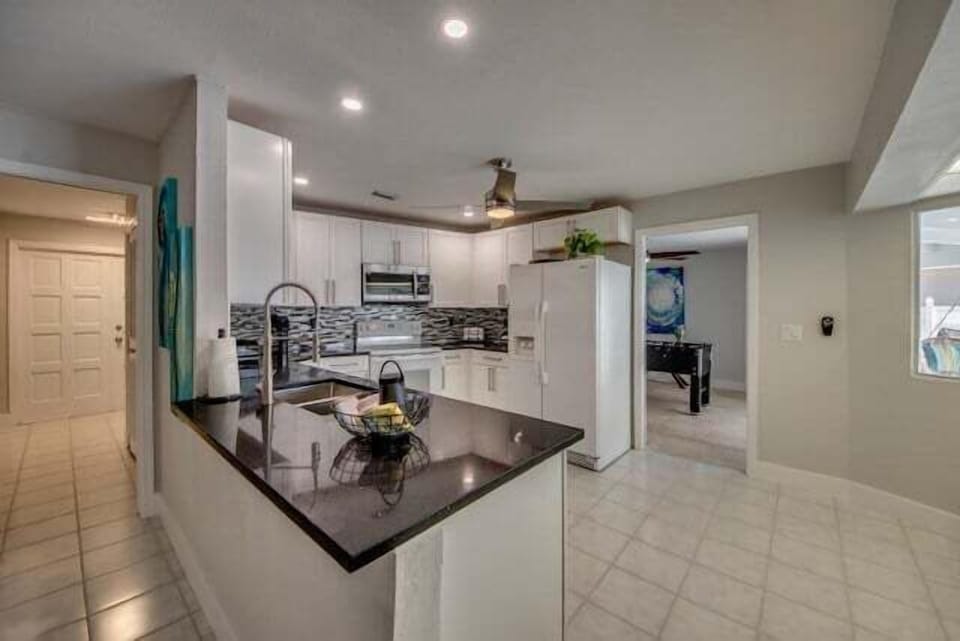 new kitchen is fully equipped with modern appliances and has a high-quality black granite worktop