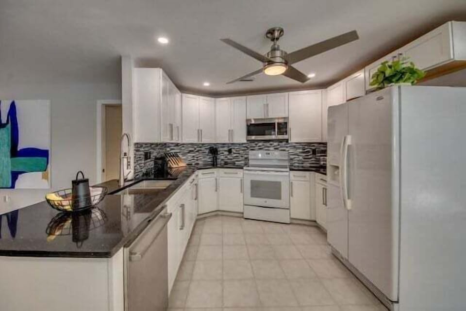 new kitchen is fully equipped with modern appliances and has a high-quality black granite worktop