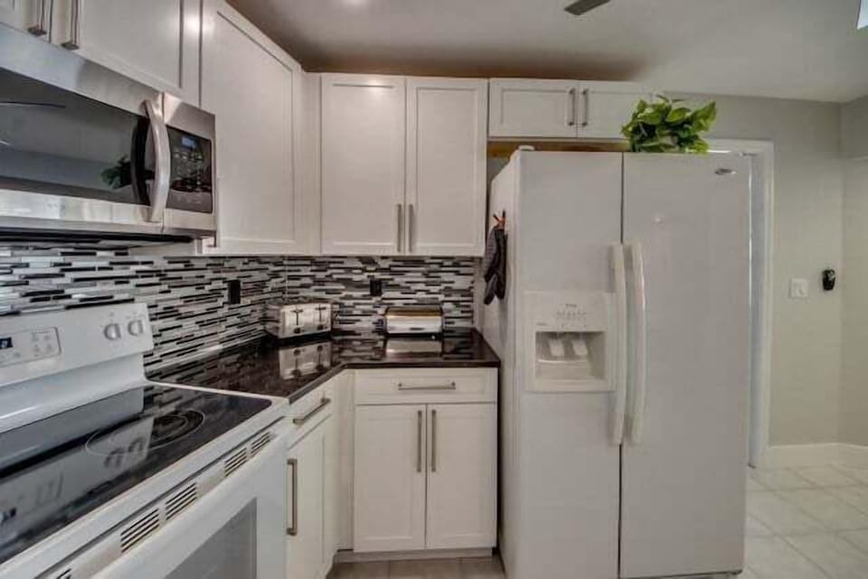 new kitchen is fully equipped with modern appliances and has a high-quality black granite worktop