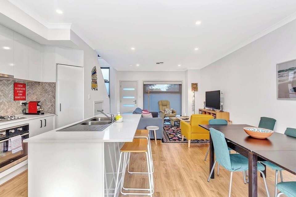 The living and dining room is open plan with a breakfast bar and dining table for meals at home.
