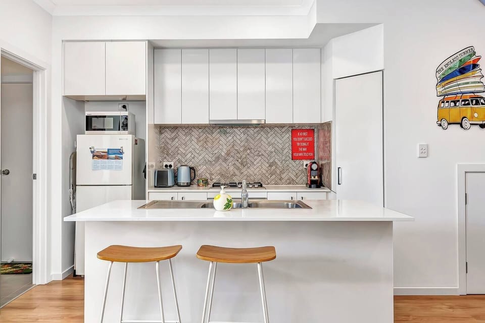 The sleek kitchen allows guests to whip up a meal at home on modern appliances and cooking utensils.

