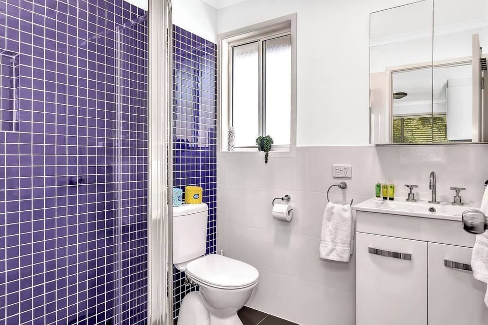 The blue theme continues on into the bathroom, with a walk-in shower and mirrored vanity with ample storage for your belongings.