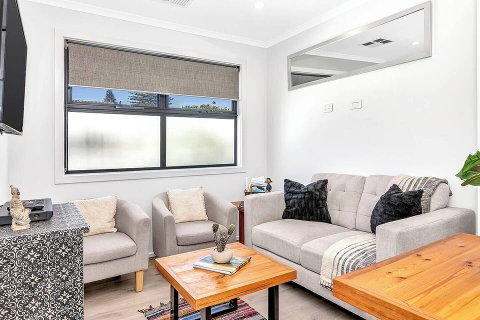 The living area offers a sofa and two armchairs where guests can settle in with a movie on the wall-mounted TV. 
