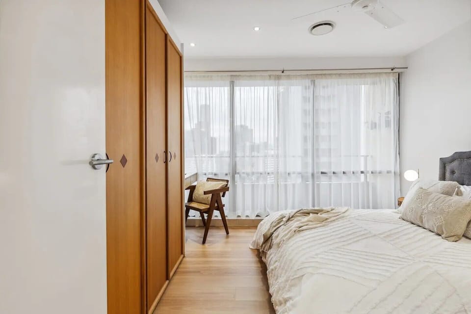 The second bedroom with queen bed, dedicated working space and city views.