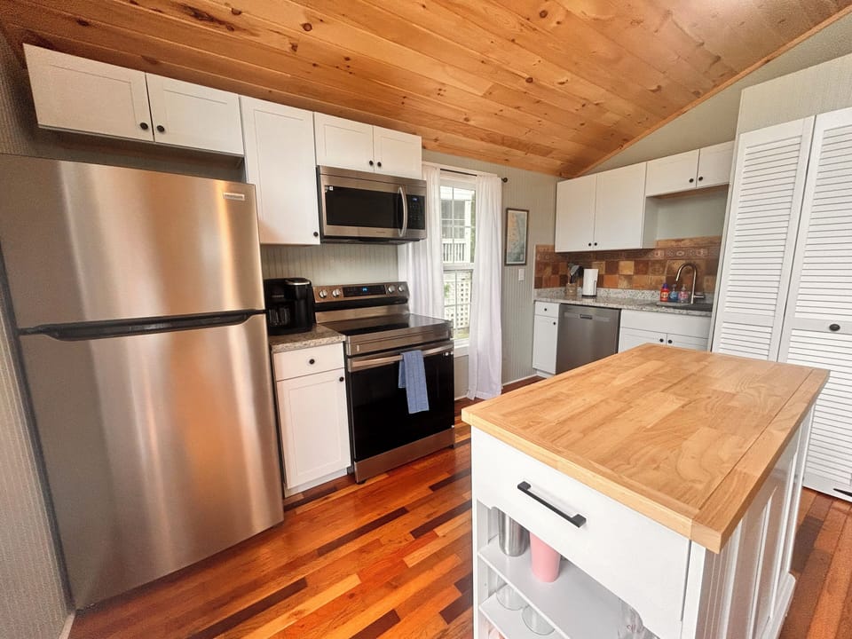 The kicthen island is a great prep space & is stocked with bar glasses & tools.