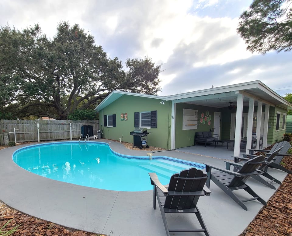 Beautiful heated pool with stylish lounge chairs and BBQ.