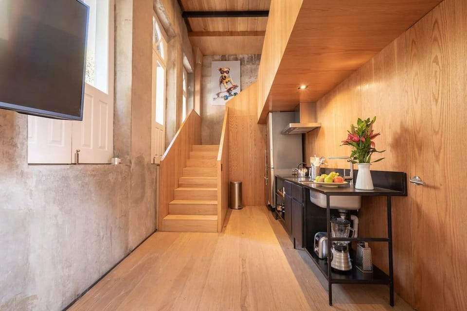 Stylish kitchen with modern appliances and a wooden staircase.