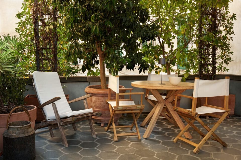 A cozy outdoor dining corner surrounded by lush greenery. Perfect for morning coffee, a quiet read, or an intimate dinner under the stars in a peaceful, leafy setting.