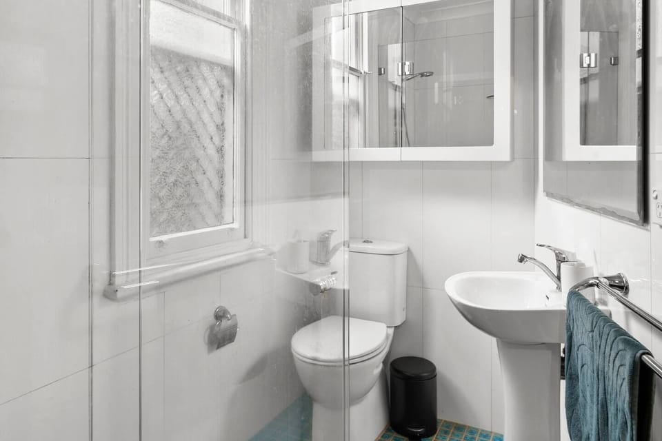 The well-appointed bathroom features a shower, toilet, and mirrored vanity, complementing your stay with modern amenities.