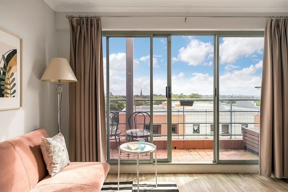 The living room opens to a balcony, capturing views over the neighbourhood and Sydney University.