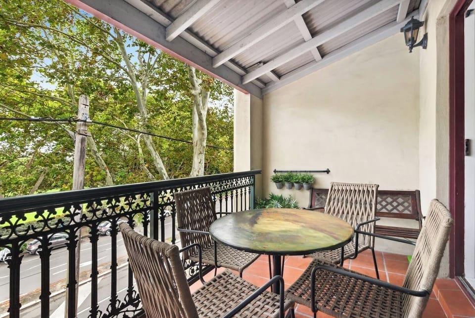 The living area extends to a balcony, overlooking the leafy neighbourhood below. This is an idyllic spot to enjoy a meal outdoors.