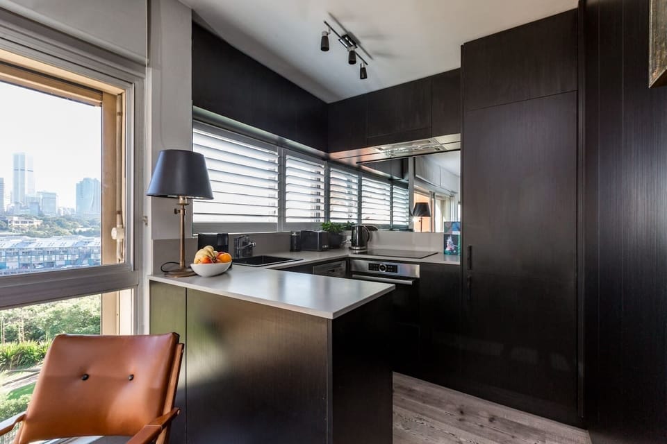 Cook up a storm in the fully-equipped kitchen makes use of space with dark, wooden cabinets and a sizable benchtop to prepare food. 