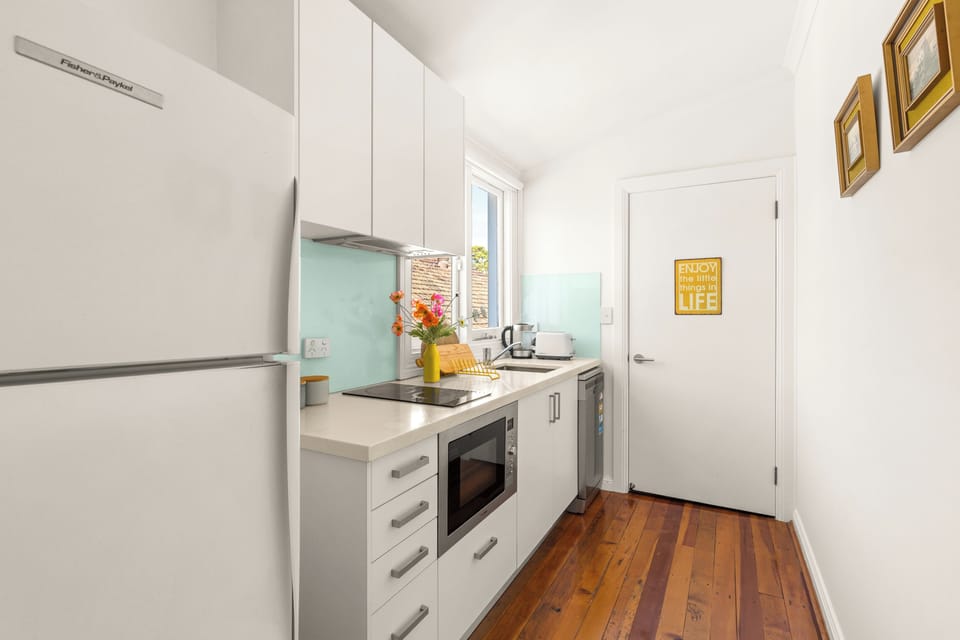 Prepare anything from a quick breakfast to dinner at home in the compact kitchen, with streamlined cabinetry and everyday cooking essentials close at hand.