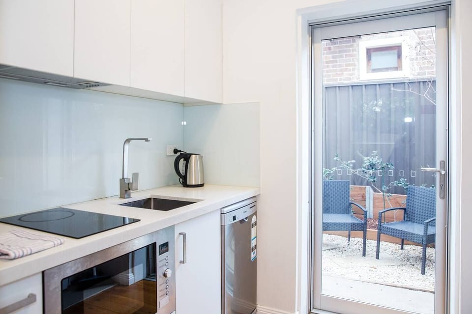 A full kitchen is kitted with top-quality appliances including a stove, microwave, dishwasher and kettle.