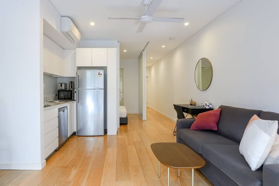 ‎The open plan living and kitchen area flows to the enclosed balcony. The bedroom has wide doors that open to both sides. 