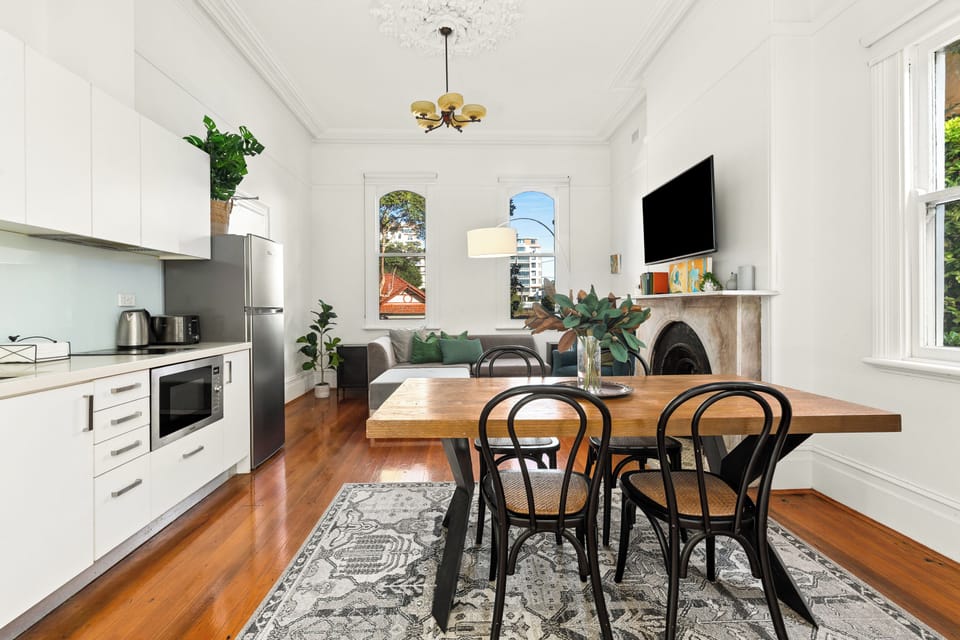 The dining table features classic Bentwood dining chairs, set for four, in the heart of the living space.
