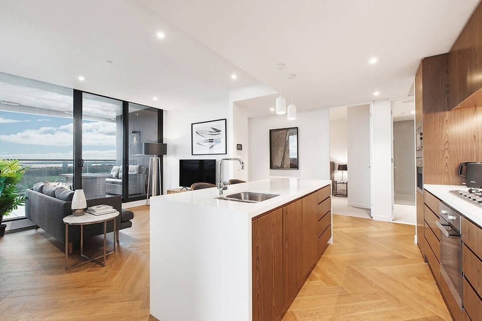 The designer centrepiece kitchen is equipped with stainless steel appliances and sleek stone to create a social heart of the home.