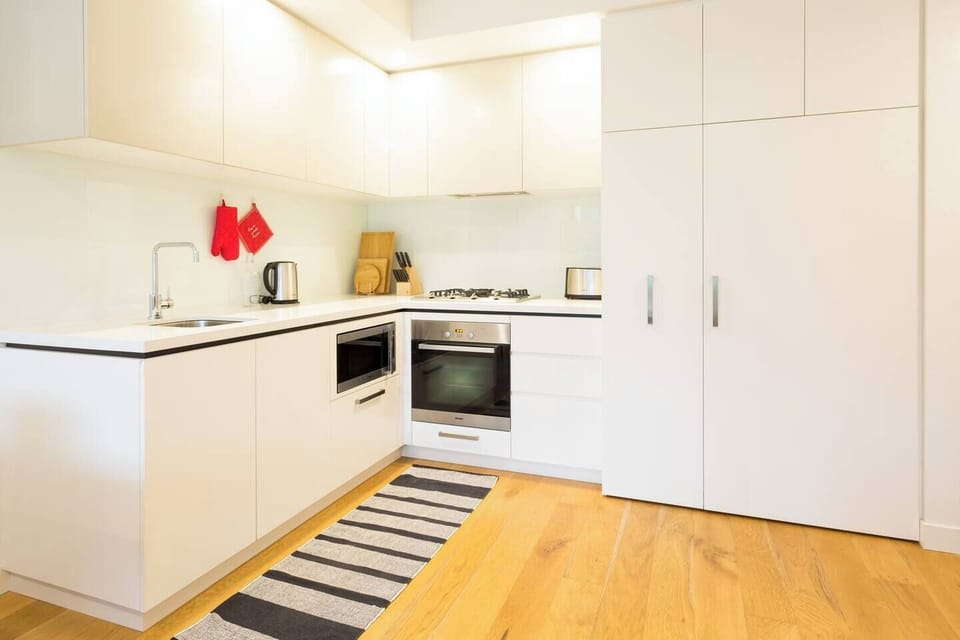 Cook from home in this white and bright kitchen complete with dishwasher, stove, oven, microwave and rice cooker