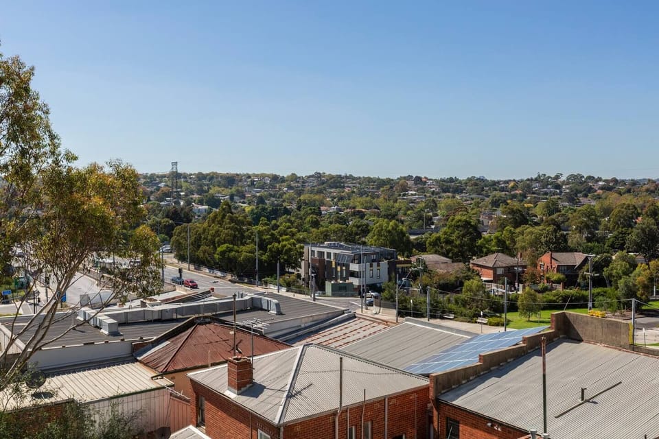 Enjoy the view from the balcony, overlooking tree-lined streets and nearby parks, perfect for leisurely walks.