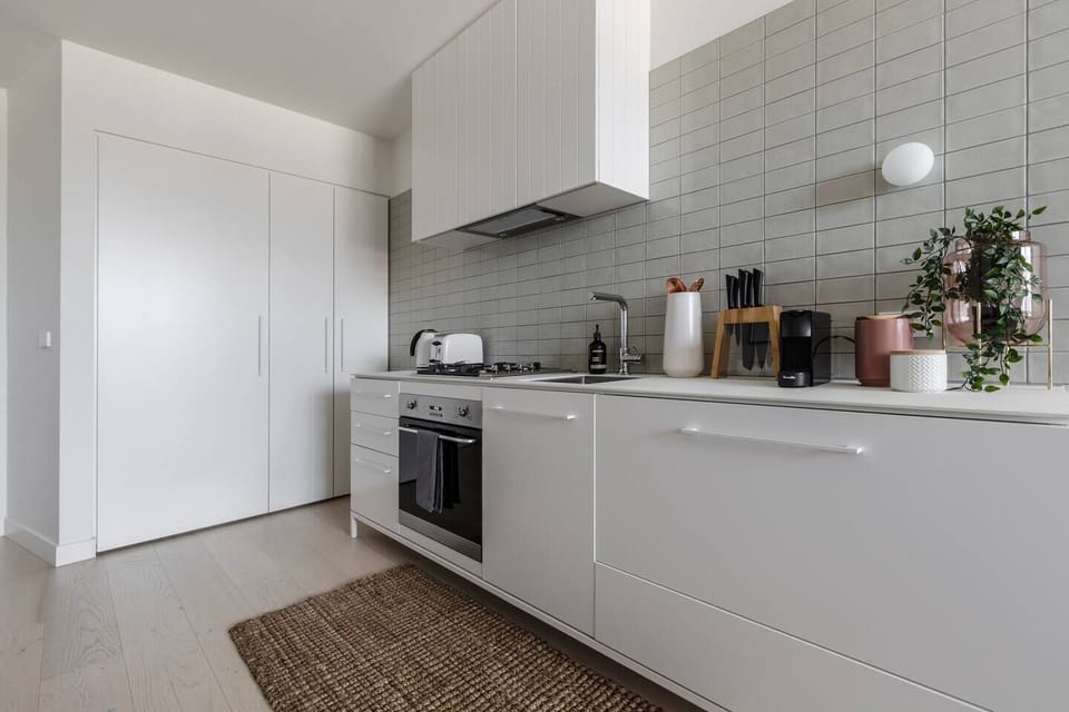 A fully-equipped kitchen is fitted with trendy SMEG appliances and state-of-the-art amenities including an oven, gas cooktop, dishwasher and large fridge
