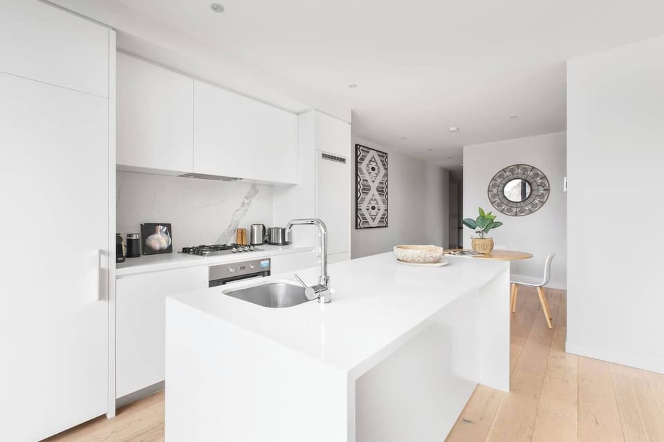 A sleek stone kitchen comes fitted with high-end stainless-steel appliances for those wanting to cook at home.
