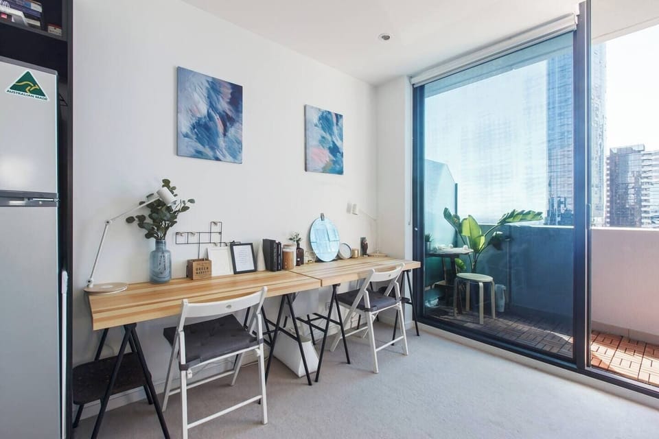The open plan layout includes a table for two and a cabinet that opens up into a desk for a dedicated workspace
