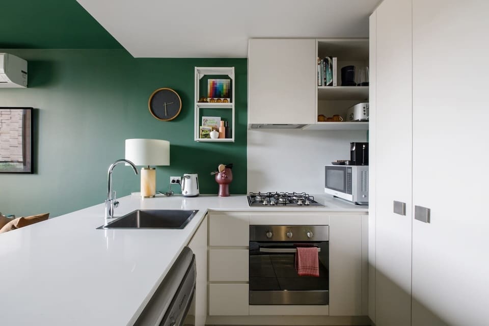 The modern, streamlined kitchen has everything that is needed to prepare meals at home. 
