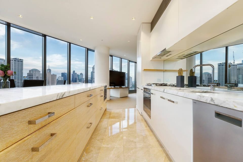 The kitchen is well equipped with high-end appliances, plenty of bench top space and a panoramic view of the CBD