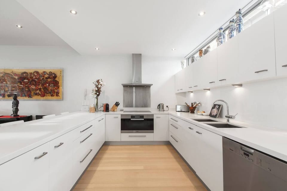 A huge kitchen is decked out with essential utensils, pantry supplies and premium appliances including an electric stovetop, oven, dishwasher and large fridge