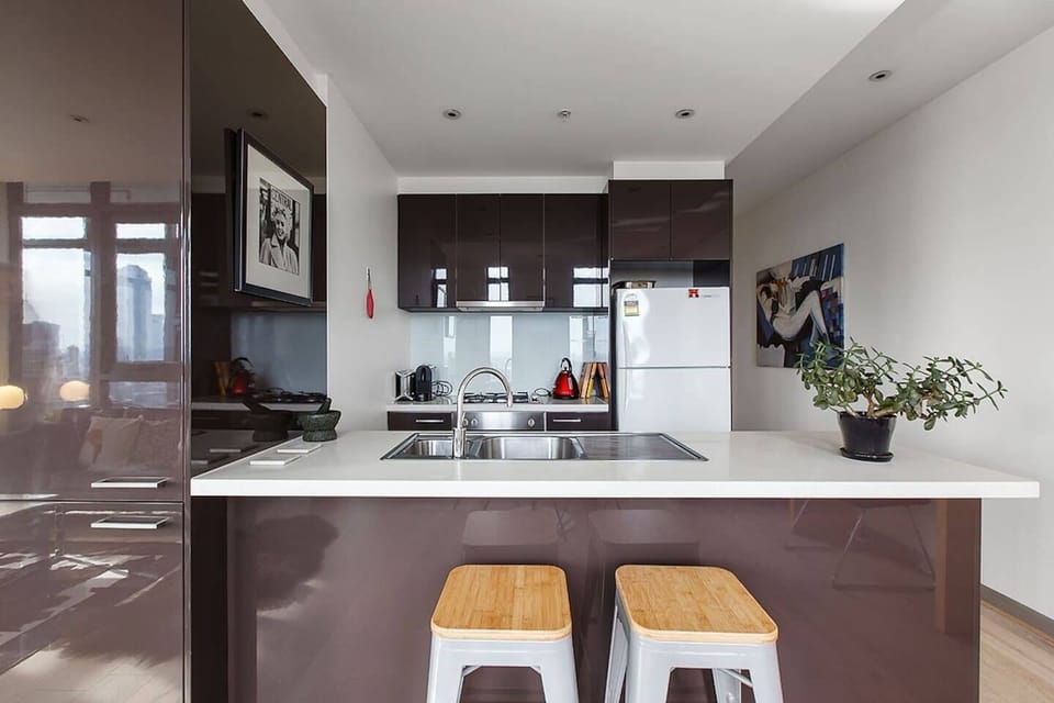 A contemporary kitchen comes dressed in premium appliances including a gas stove, oven, large fridge, dishwasher, Nespresso machine and all the cooking basics.