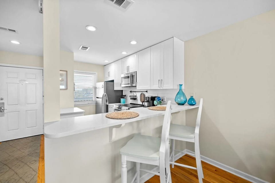 White countertop with barstool seating and coastal decor accents.