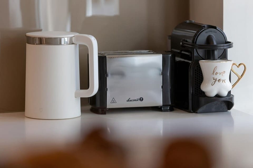 A close-up of the coffee station, showing a coffee machine, electric kettle, and cups.






