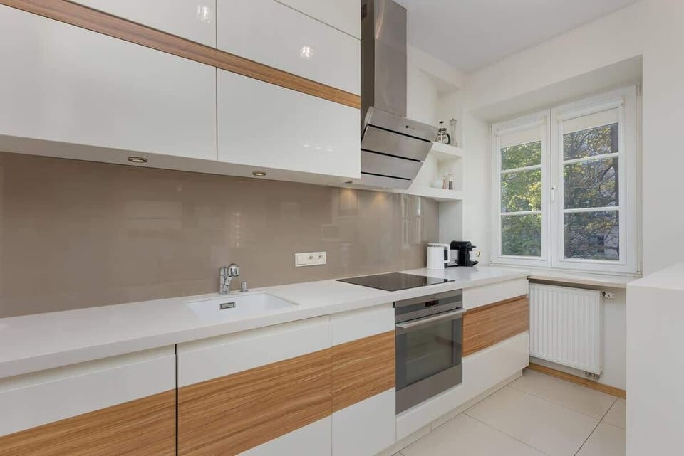 A kitchen island with bar stools, a built-in stovetop, and a modern white-and-wood design.

