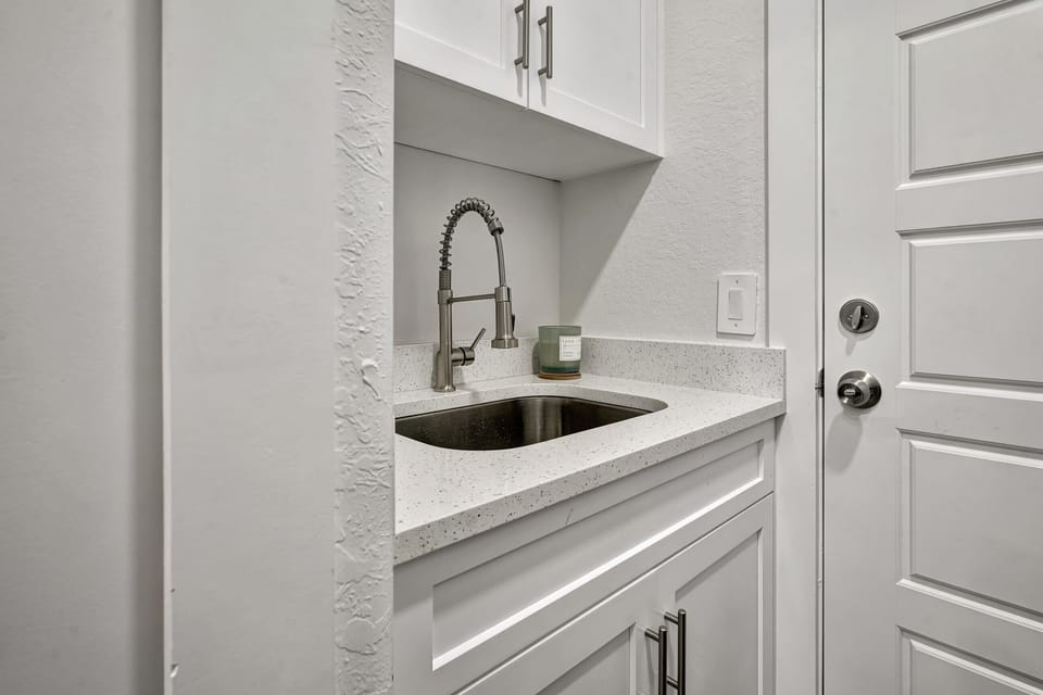 The laundry room includes a wash sink, the door leads to the garage
